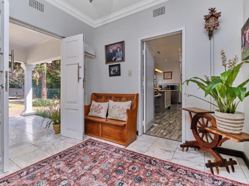 Welcoming entrance hall featuring elegant marble flooring, crown molding, and direct access to the outdoor patio and interior living spaces.