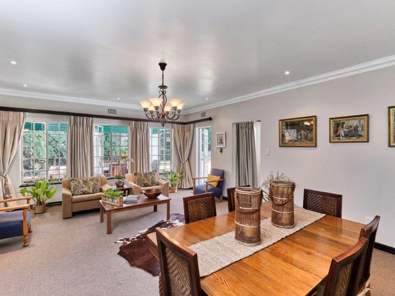 Spacious open-plan living and dining area featuring neutral walls, recessed lighting, and large windows providing ample natural light and access to the outdoor space.