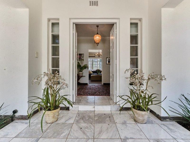 A welcoming front entrance featuring a tiled porch, double doors with sidelight windows, and a clear view into the home's interior hallway.