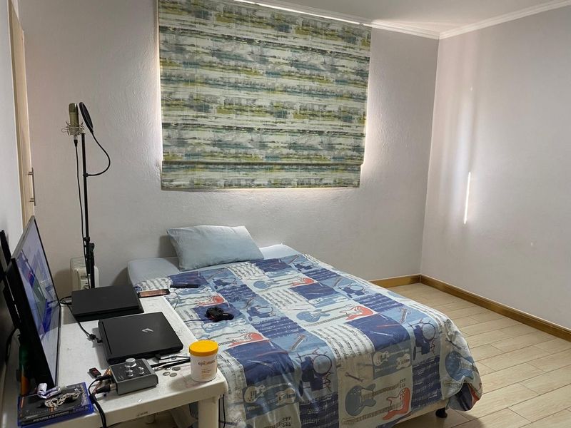 A functional bedroom featuring tiled flooring and a patterned roman blind, providing a neutral base for personalization.