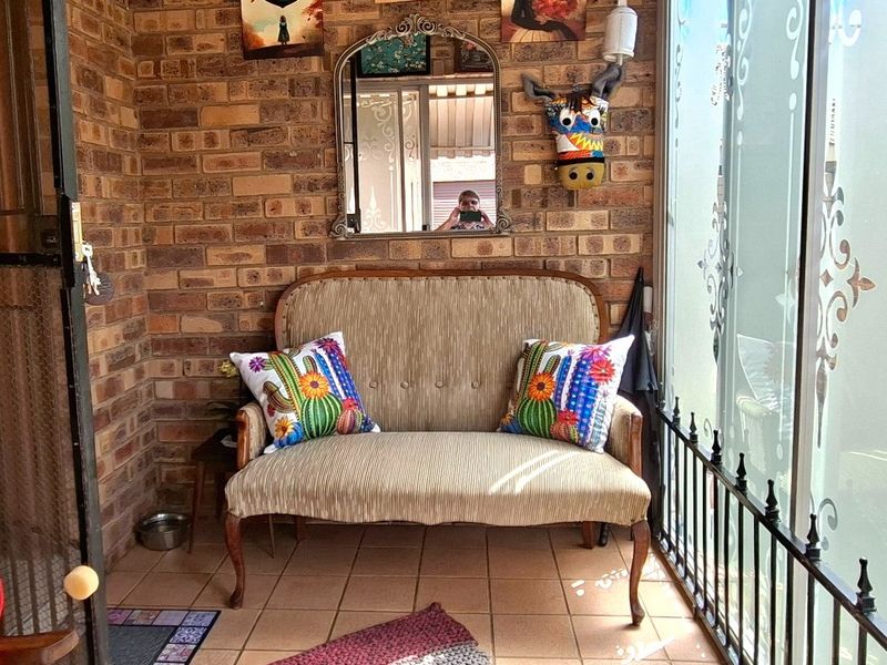 Enclosed patio area featuring exposed brick walls, tiled flooring, and large glass sliding doors with decorative frosting.
