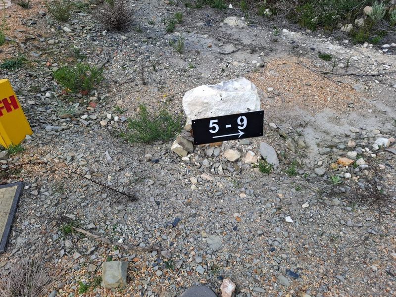 A close-up view of a property boundary marker indicating plot numbers 5-9 on a vacant residential lot.