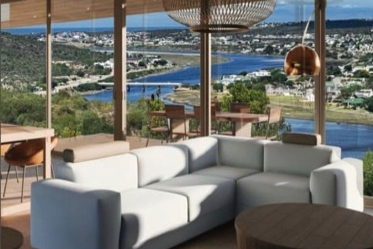 Modern living area featuring expansive floor-to-ceiling glass windows that offer panoramic views of the river and surrounding landscape.