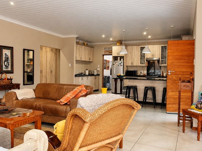 Spacious open-plan living area featuring a modern kitchen with built-in cabinetry, a breakfast island, and tiled flooring throughout.