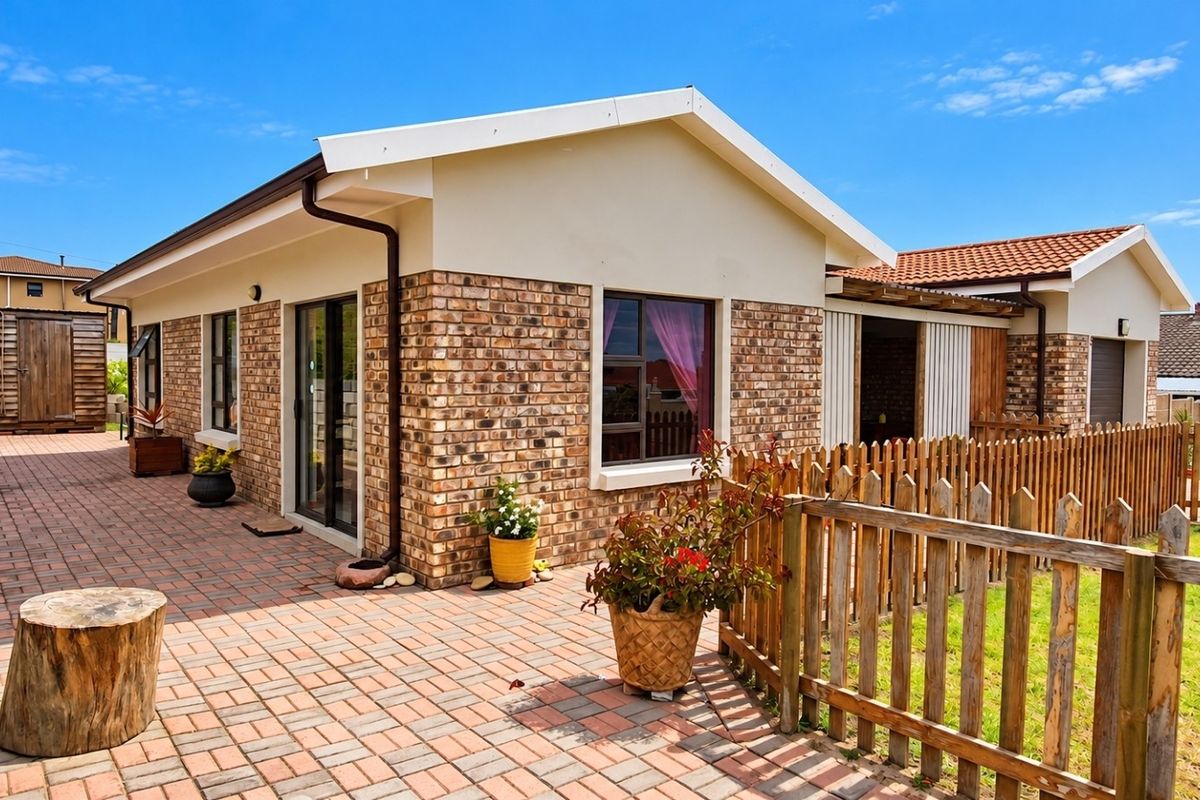 A well-maintained rear exterior view featuring a brick facade, paved patio area, and timber picket fencing, providing a clean and inviting outdoor space.
