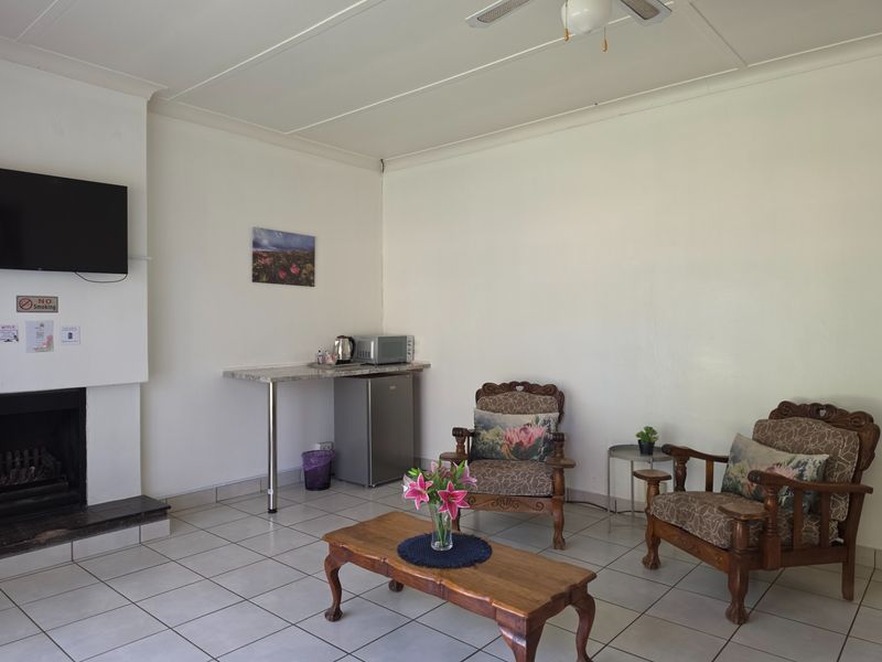 A living room featuring tiled flooring, a fireplace, and a built-in counter area, providing a functional space for guests.
