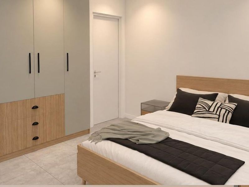 A modern bedroom featuring neutral-toned built-in wardrobes with integrated drawers and sleek tiled flooring.