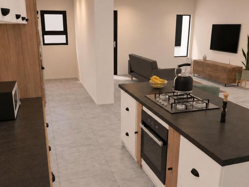 Modern open-plan living area featuring a contemporary kitchen with a central island, built-in oven, gas cooktop, and sleek cabinetry, seamlessly flowing into the living space.