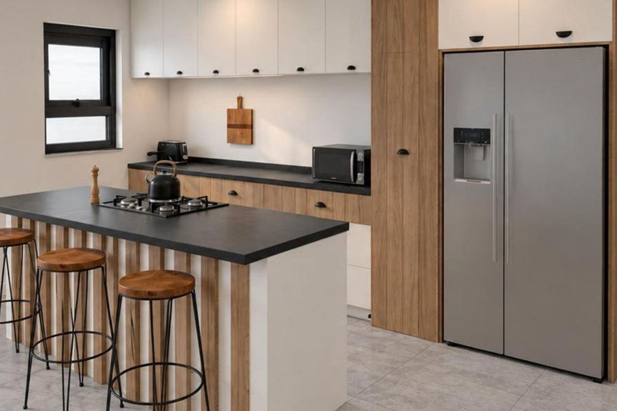 Modern kitchen featuring a central island with a gas hob, sleek two-tone cabinetry, stone countertops, and contemporary tiled flooring.