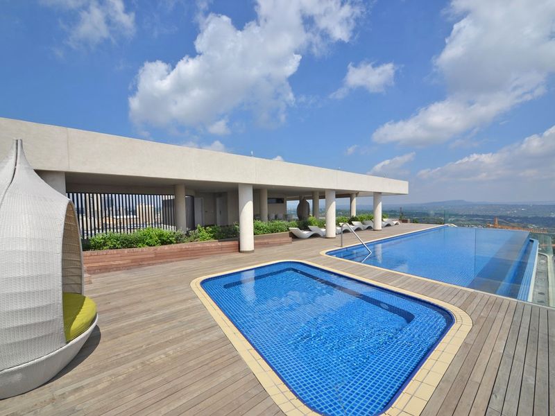 Rooftop terrace featuring an infinity pool, plunge pool, timber decking, and panoramic views, providing a luxurious outdoor leisure space.
