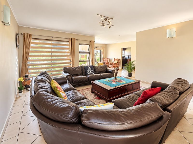Spacious open-plan living area featuring tiled flooring, neutral wall tones, and large windows with modern roller blinds, creating a bright and inviting atmosphere.