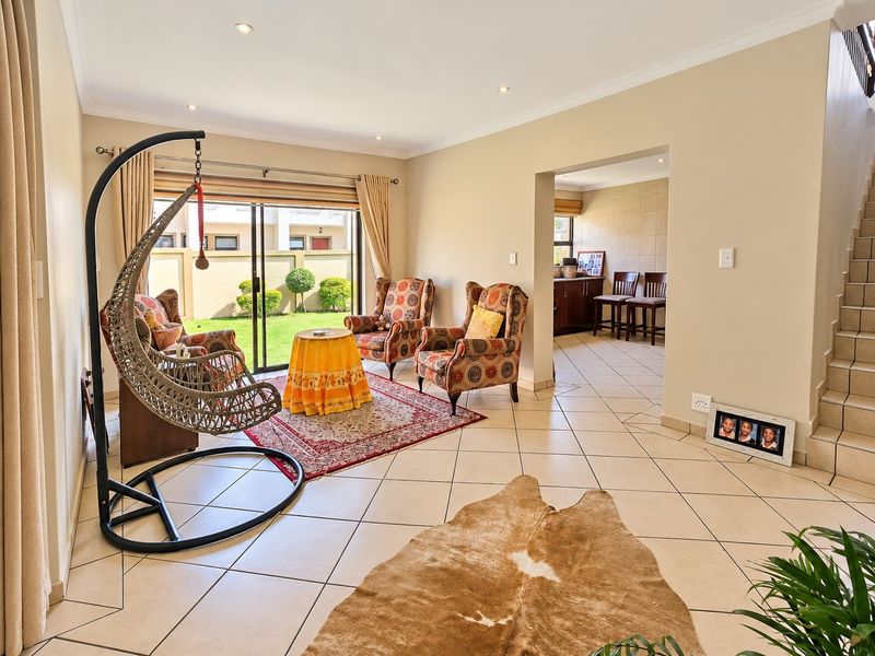 Spacious open-plan living area featuring tiled flooring, recessed lighting, and sliding glass doors providing direct access to the rear garden.