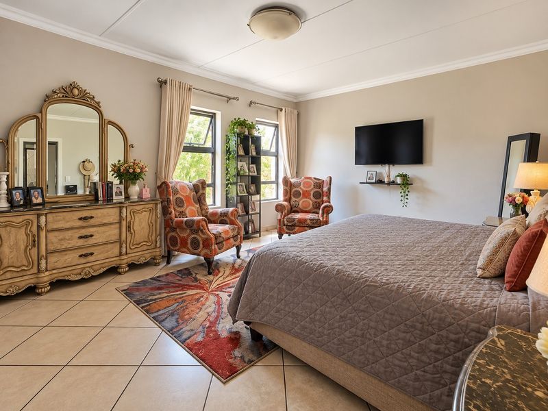 Spacious bedroom featuring neutral wall tones, tiled flooring, and large windows that provide ample natural light.