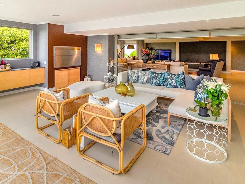 Spacious open-plan living area featuring modern tiled flooring, built-in cabinetry, and seamless flow to an adjacent lounge space with a fireplace.