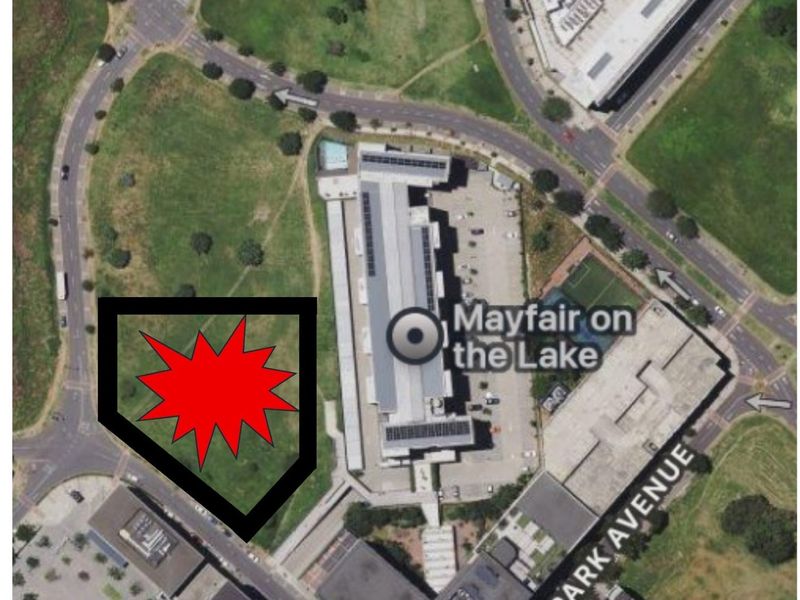 Aerial view of a vacant commercial land plot located adjacent to the Mayfair on the Lake building complex.