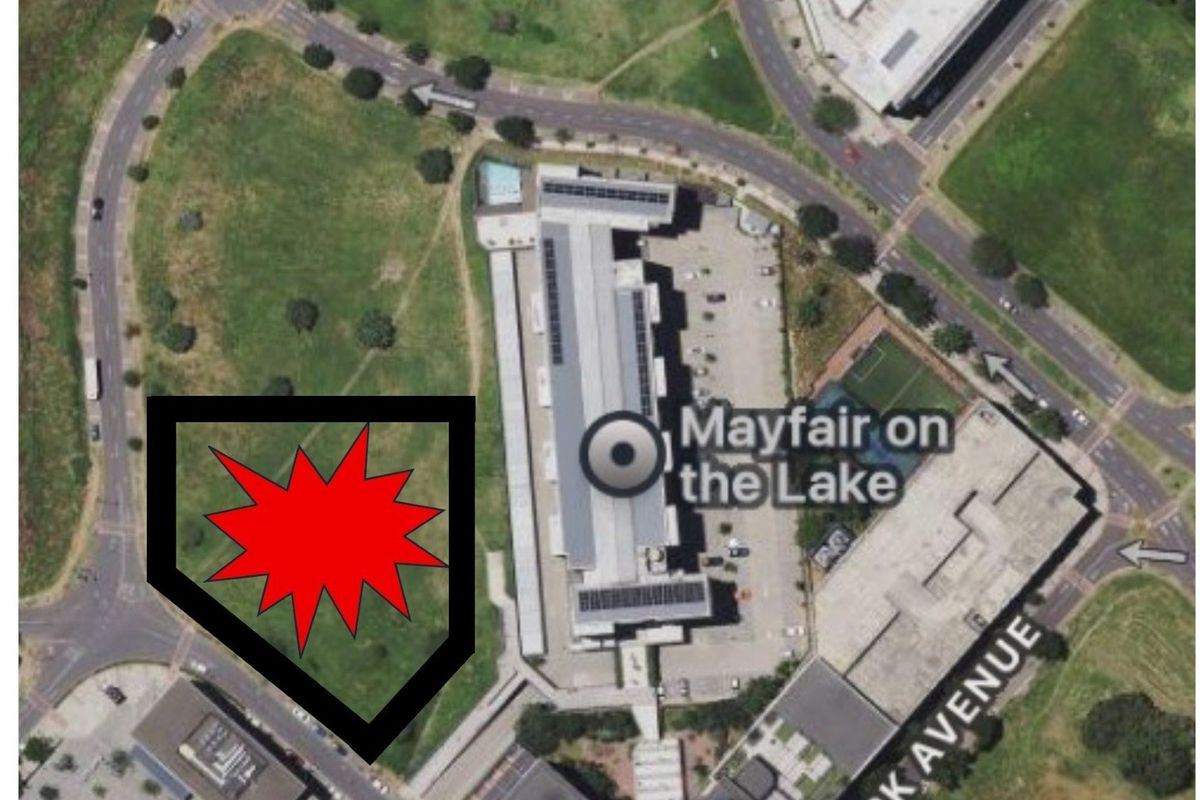 Aerial view of a vacant commercial land plot located adjacent to the Mayfair on the Lake building complex.
