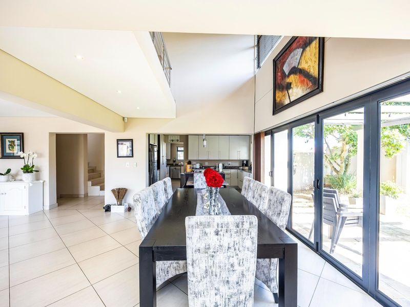 Spacious open-plan dining and kitchen area featuring large sliding glass doors that provide seamless access to the outdoor patio and garden.