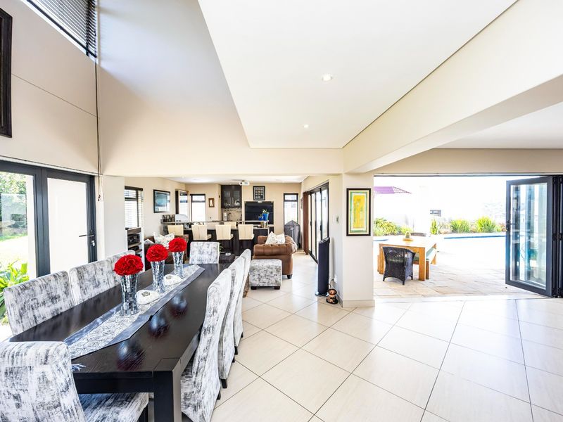 Spacious open-plan living and dining area featuring tiled floors, recessed lighting, and seamless indoor-outdoor flow through large bi-fold doors to the patio.
