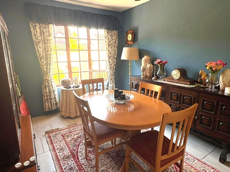 A dining room featuring tiled flooring and a large multi-pane window, providing a functional space for meals.