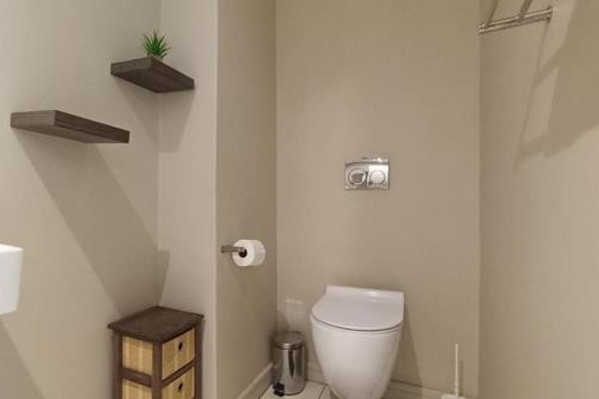 A modern bathroom featuring a wall-hung toilet with a concealed cistern, a wall-mounted basin, and a towel rail.