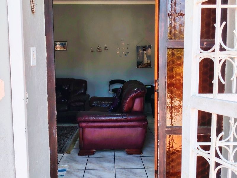 View through the entrance doorway into a living area featuring tiled flooring and a security gate.