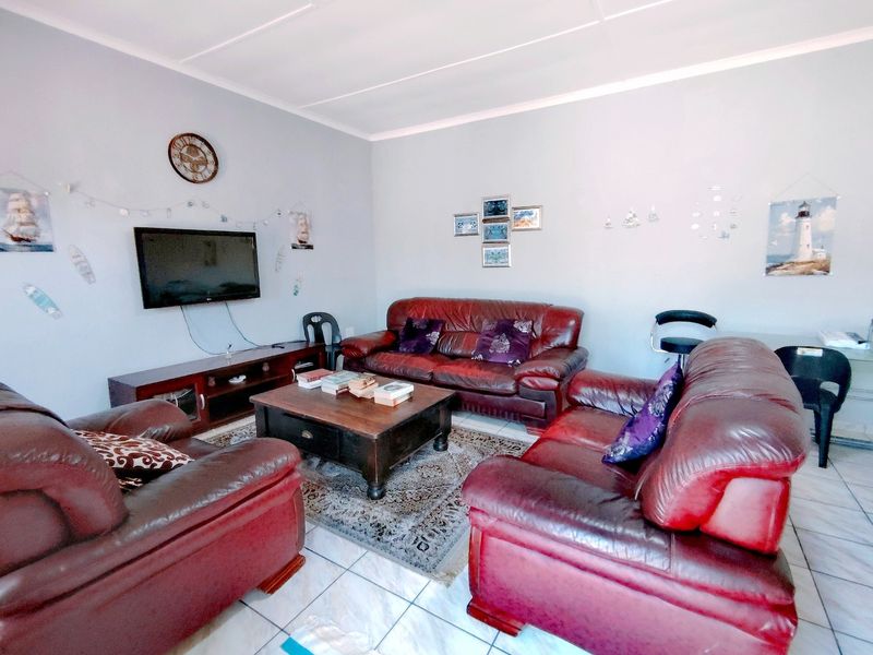 A comfortable living room featuring tiled flooring and a coved ceiling, providing a functional space for relaxation.