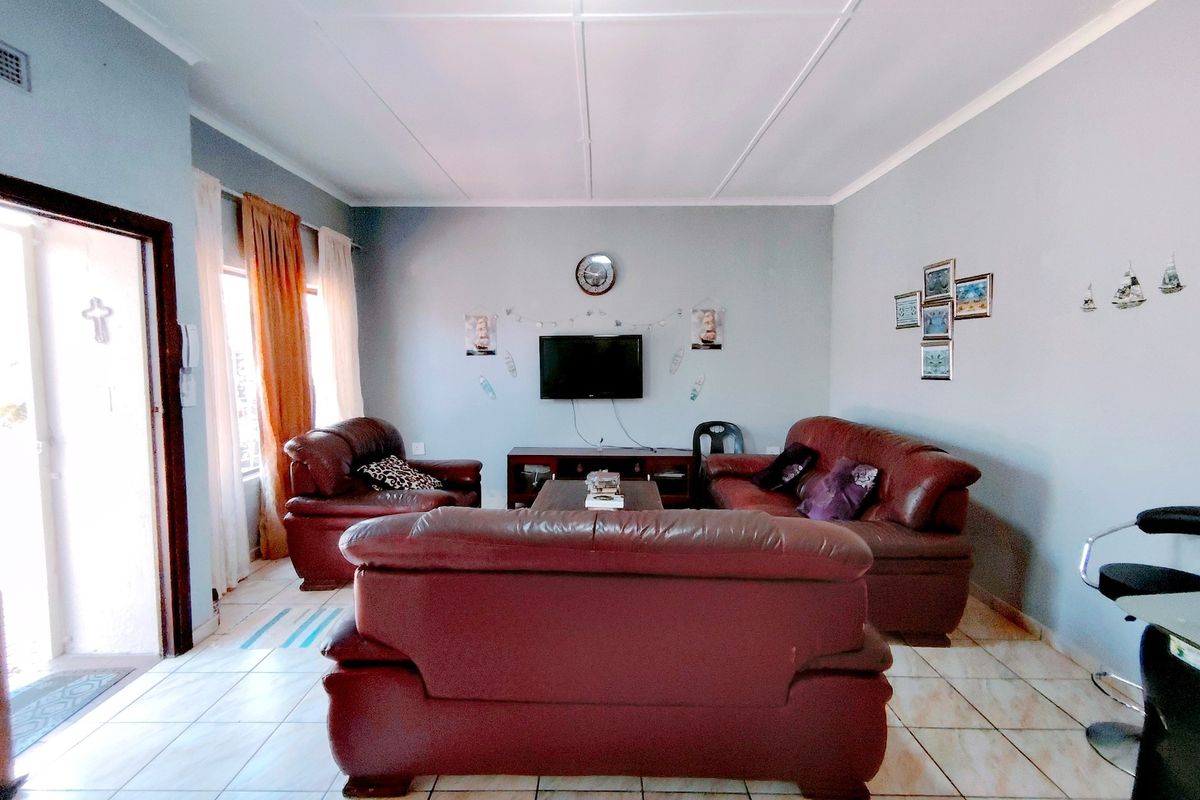 A living room featuring tiled flooring and a sliding door leading to the exterior.