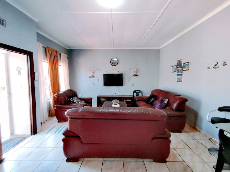 A living room featuring tiled flooring and a sliding door leading to the exterior.