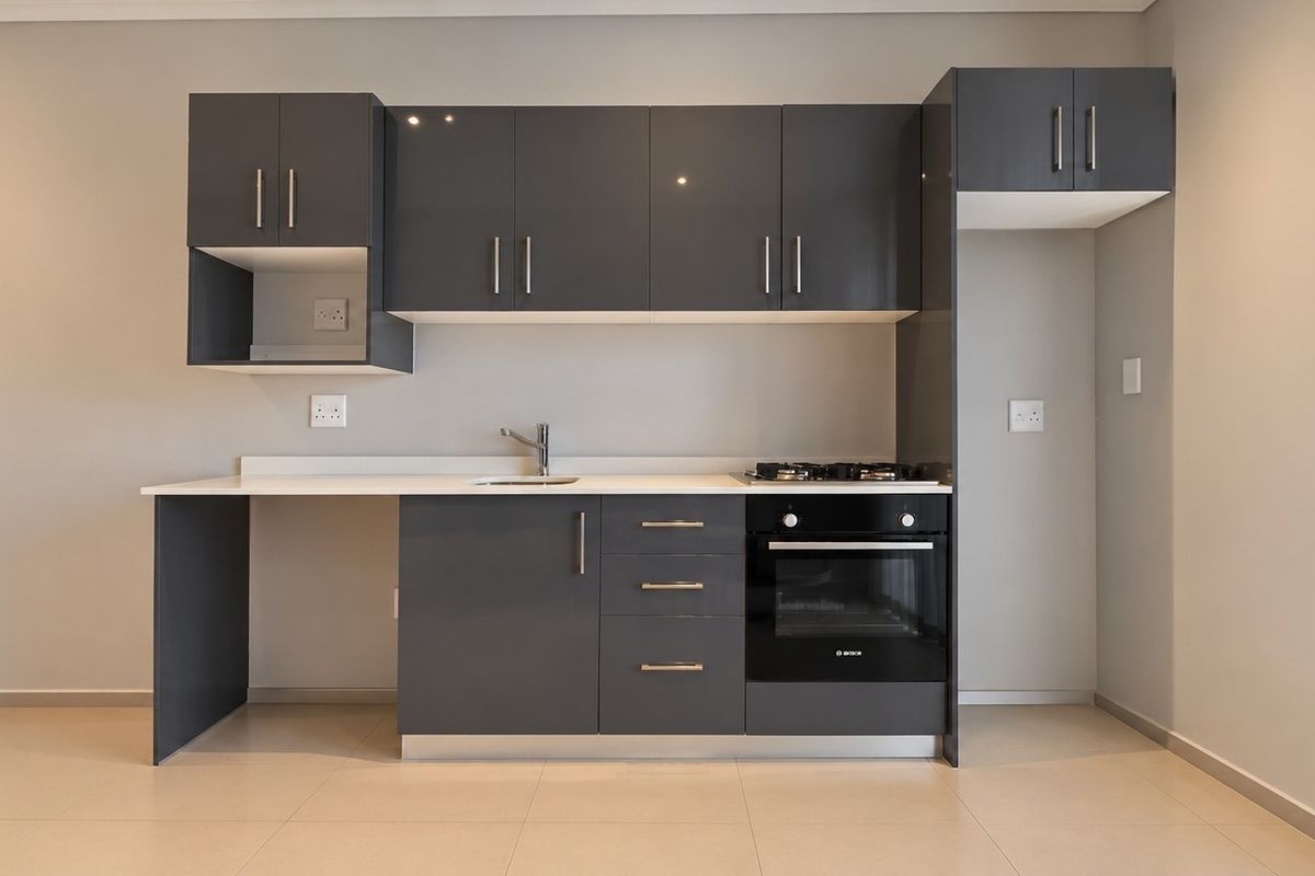 Modern kitchen featuring sleek dark grey cabinetry, stone countertops, built-in oven, gas cooktop, and tiled flooring in a clean, minimalist layout.