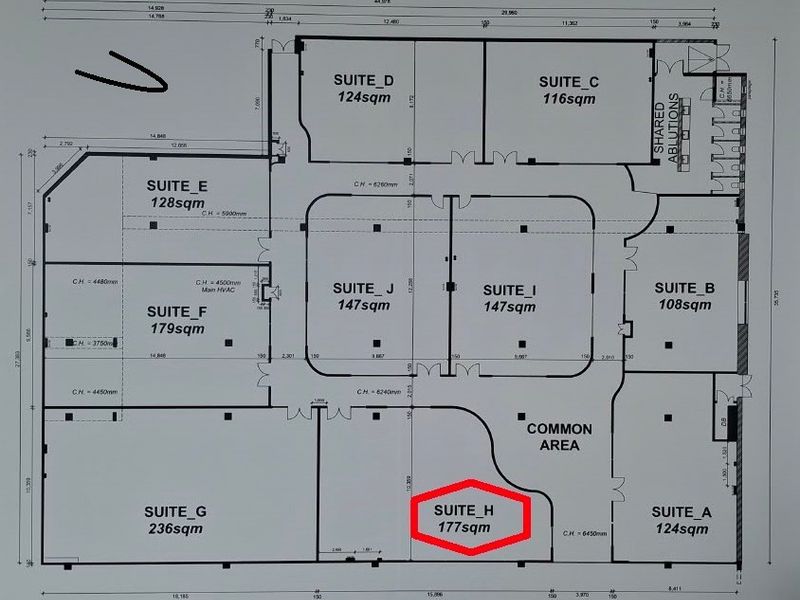 A detailed floor plan of an office building layout, highlighting various suites, shared ablutions, and a common area.