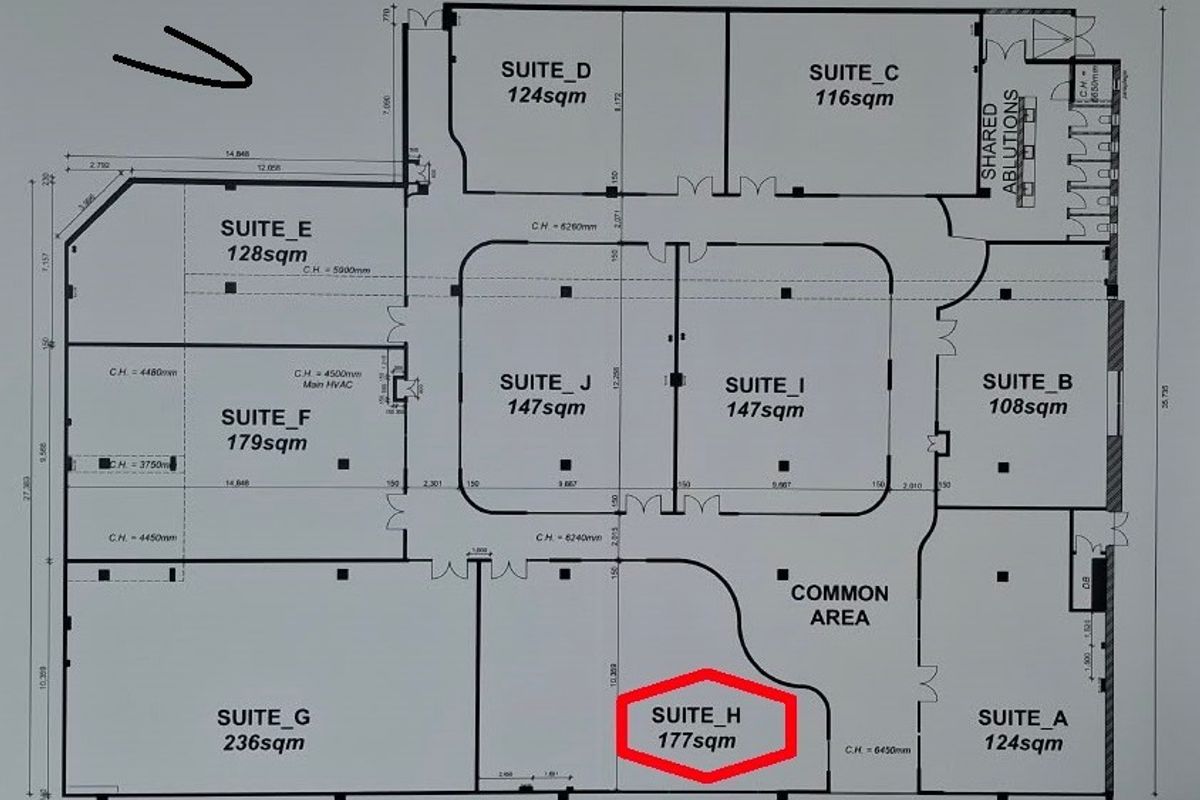 A detailed floor plan of an office building layout, highlighting various suites, shared ablutions, and a common area.