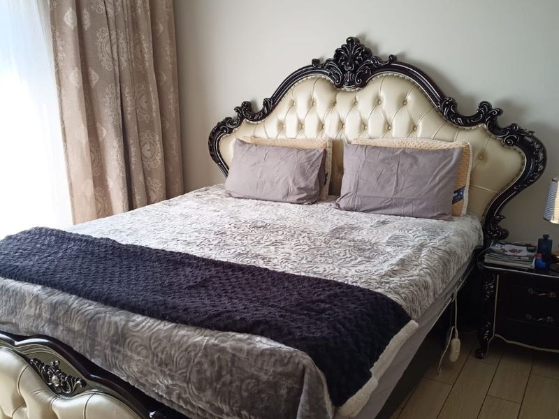 A well-maintained bedroom featuring light-toned laminate flooring and neutral wall finishes, providing a comfortable and functional sleeping space.
