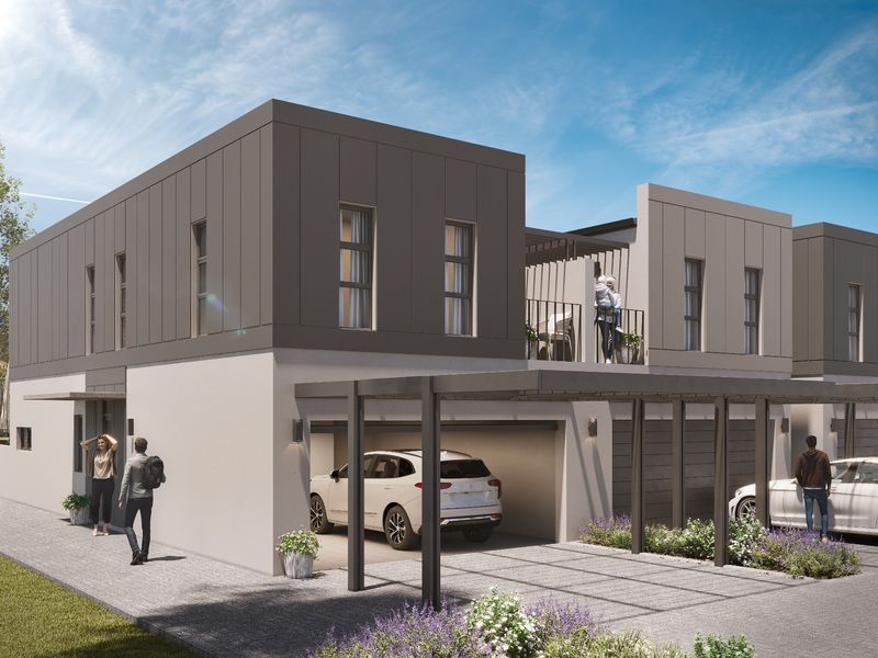 Modern two-story residential facade featuring contemporary metal cladding, a covered carport, and an upper-level balcony.