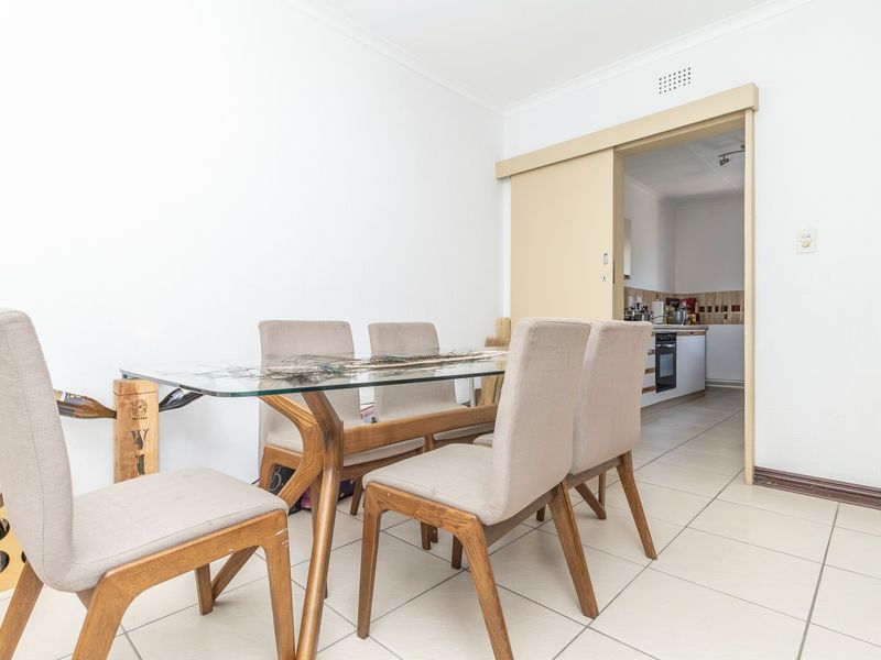 Dining area with tiled flooring and a sliding door providing access to the adjacent kitchen.