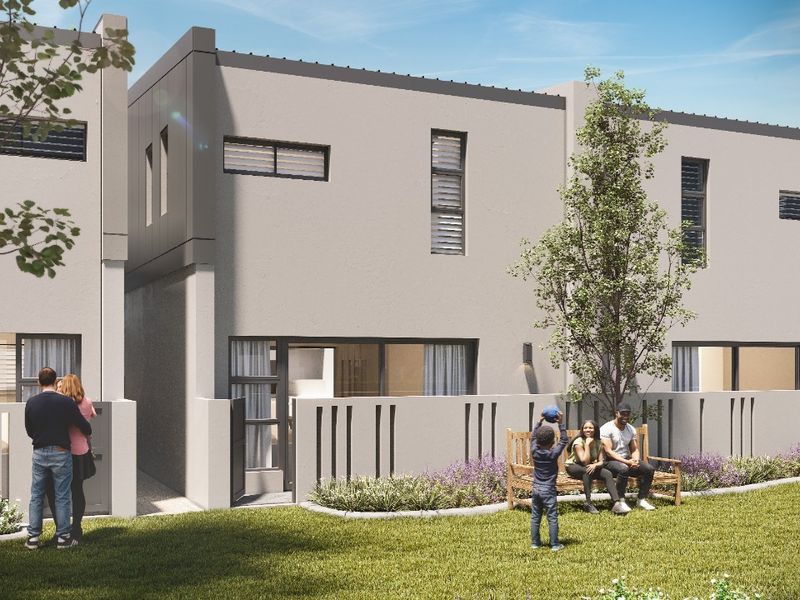 A modern rear exterior view of a townhouse featuring a landscaped garden, boundary wall, and contemporary architectural finishes.
