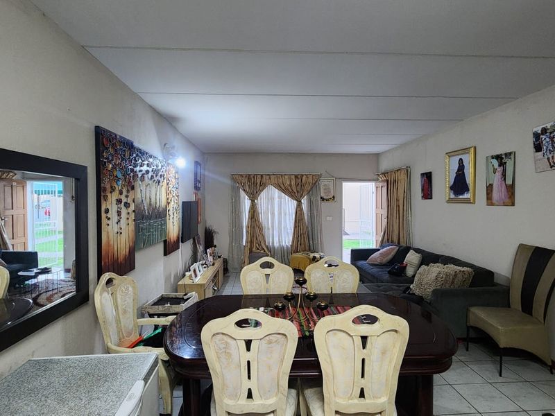 Open-plan living and dining area featuring tiled flooring and direct access to an outdoor space through a sliding glass door.