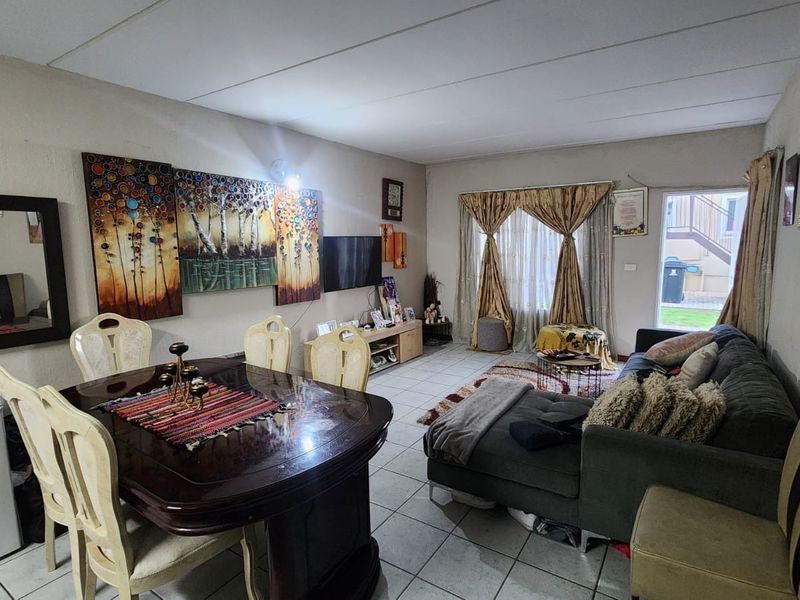 Open-plan living and dining area featuring tiled flooring and a sliding glass door providing access to the exterior.