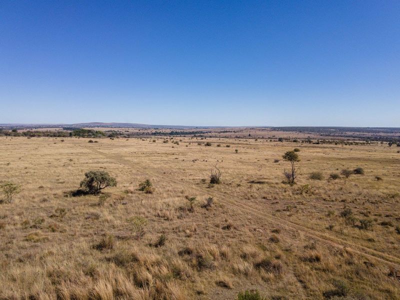 An aerial view of the expansive, open grassland landscape characteristic of the farm property.