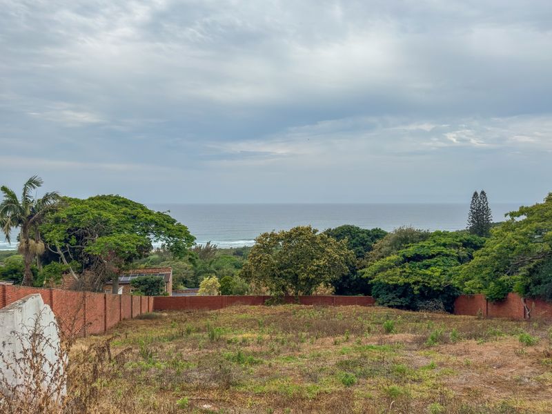 A vacant residential plot featuring a clear ocean view and established brick boundary walls, offering a prime opportunity for coastal development.