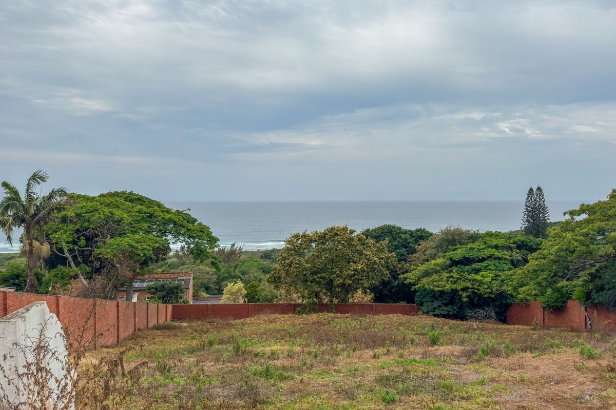 A vacant residential plot featuring a clear ocean view and established brick boundary walls, offering a prime opportunity for coastal development.