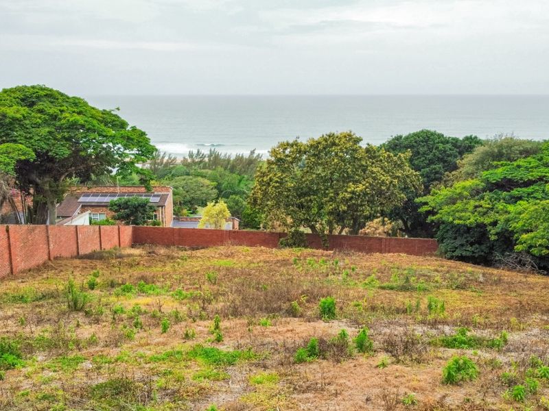 A vacant residential plot featuring a brick boundary wall and scenic coastal views, offering potential for development in a desirable location.