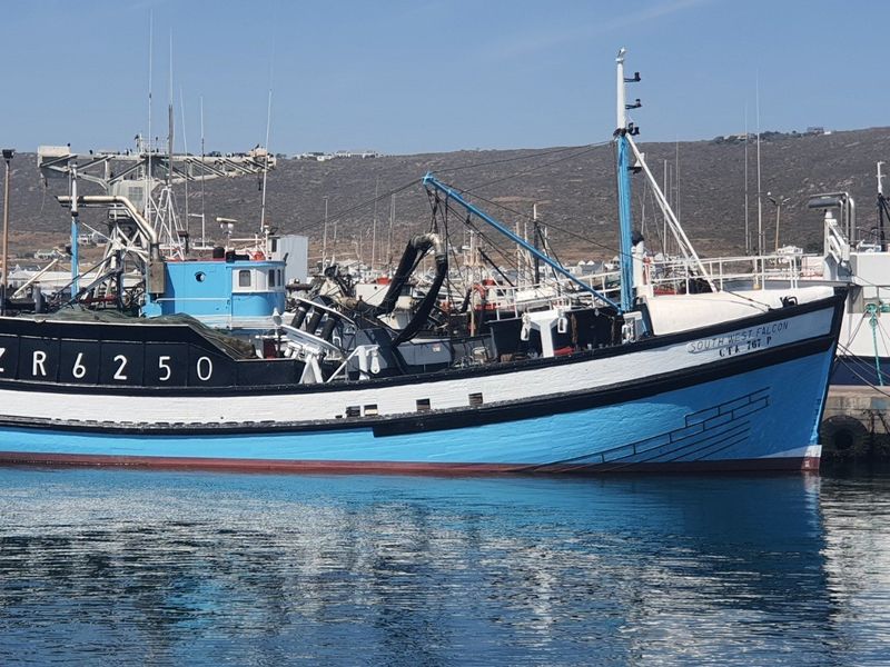 A view of a commercial fishing vessel docked in a harbor.