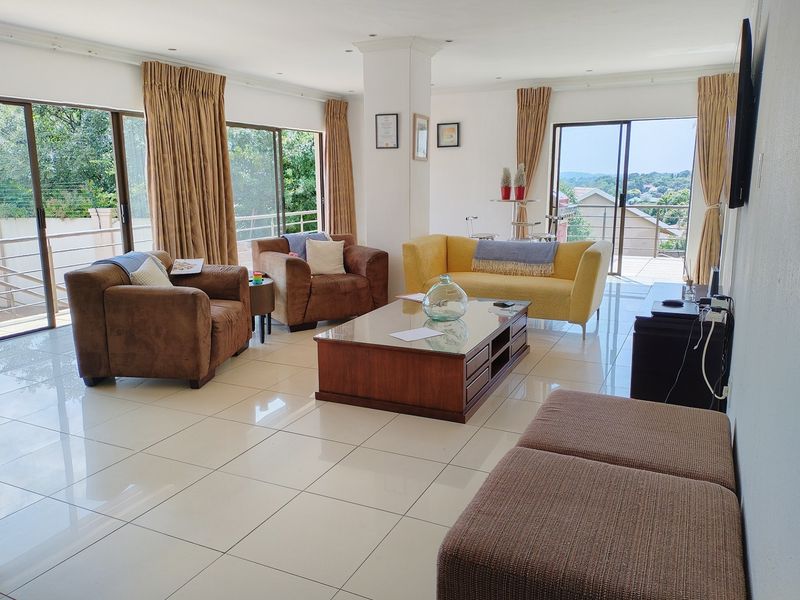 Spacious living room featuring large sliding glass doors that provide ample natural light and access to the outdoor area, complemented by polished tiled flooring.