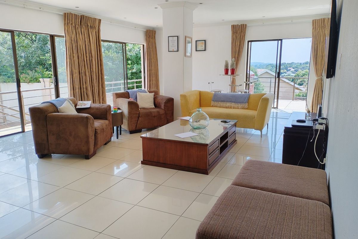 Spacious living room featuring large sliding glass doors that provide ample natural light and access to the outdoor area, complemented by polished tiled flooring.