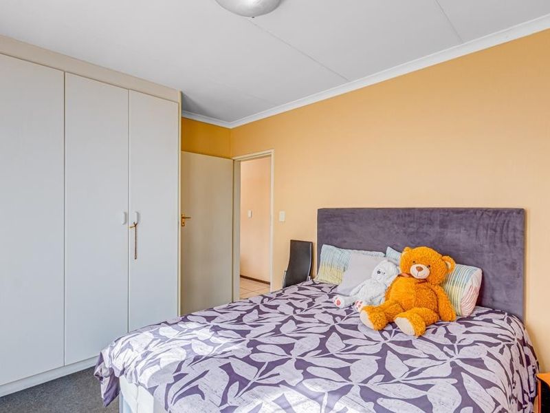 A functional bedroom featuring built-in cupboards, carpeted flooring, and a coved ceiling, providing a comfortable and practical living space.