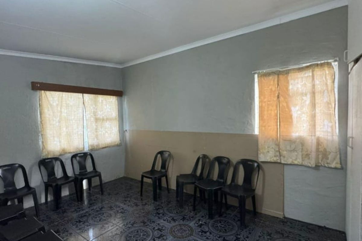 A simple living area featuring tiled flooring and a built-in cupboard, offering a blank canvas for potential interior updates and renovation.