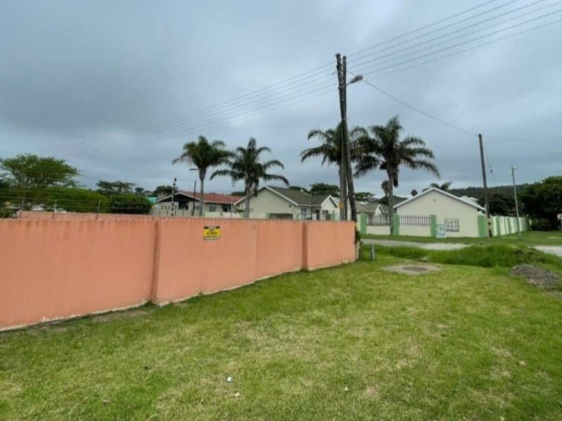 Street view showing a residential perimeter wall with electric fencing and surrounding neighbourhood context.