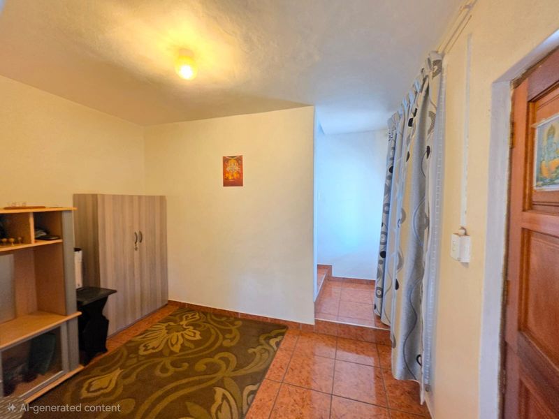 A bedroom featuring tiled flooring and a wooden door, requiring cosmetic updates to improve the overall finish and lighting.