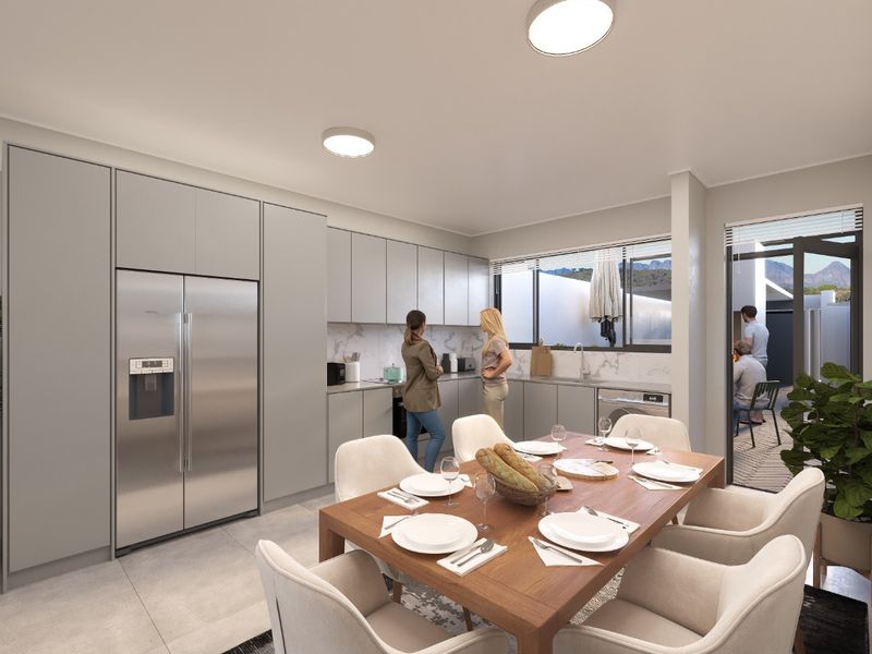 Modern open-plan kitchen and dining area featuring sleek grey cabinetry, marble-look backsplash, and direct access to an outdoor patio space.