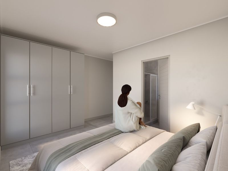 Modern bedroom featuring neutral tones, ample built-in wardrobe storage, and direct access to an en-suite bathroom.